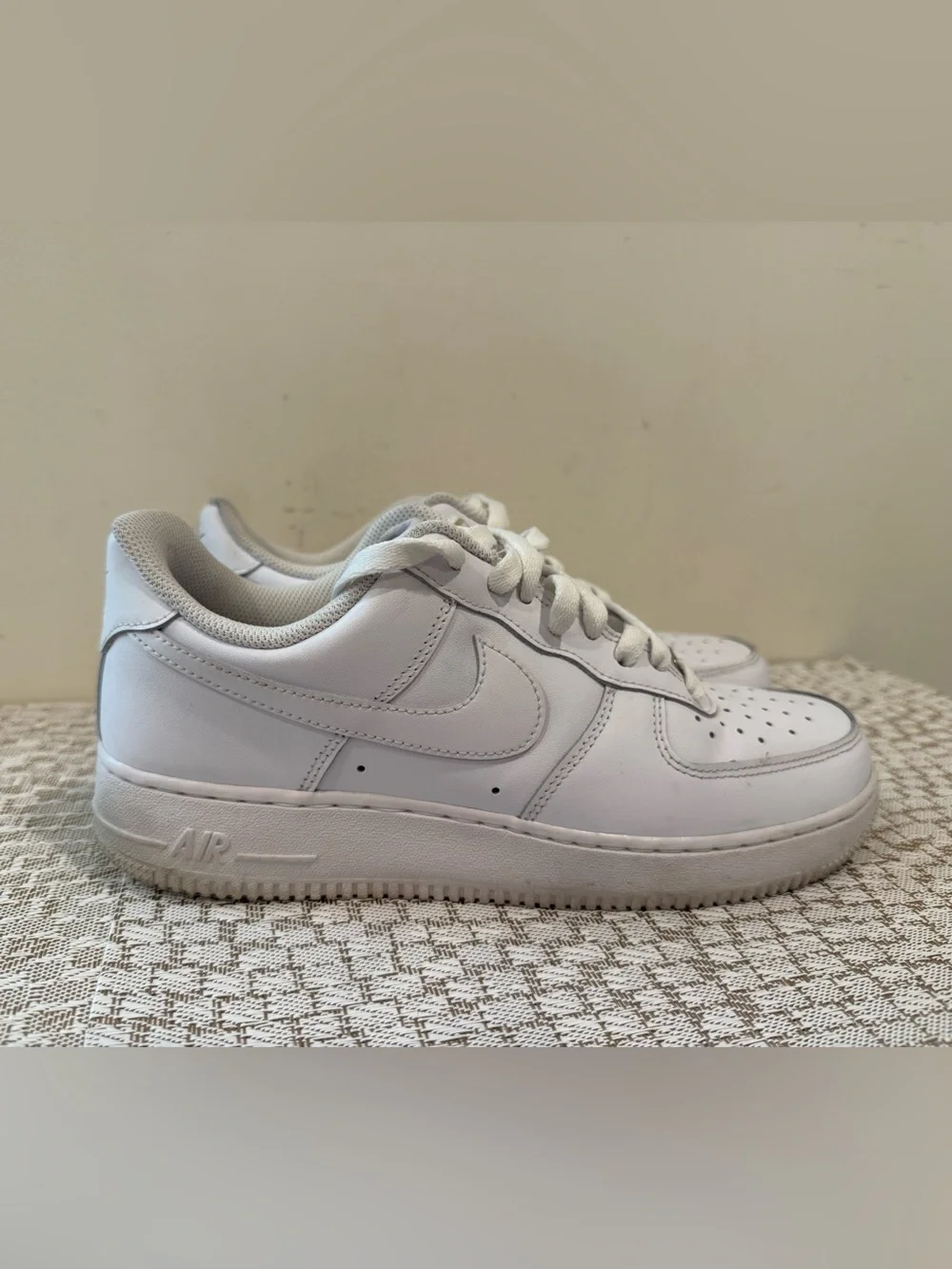 These are iconic Nike Air Force 1 sneakers in an all-white colorway.